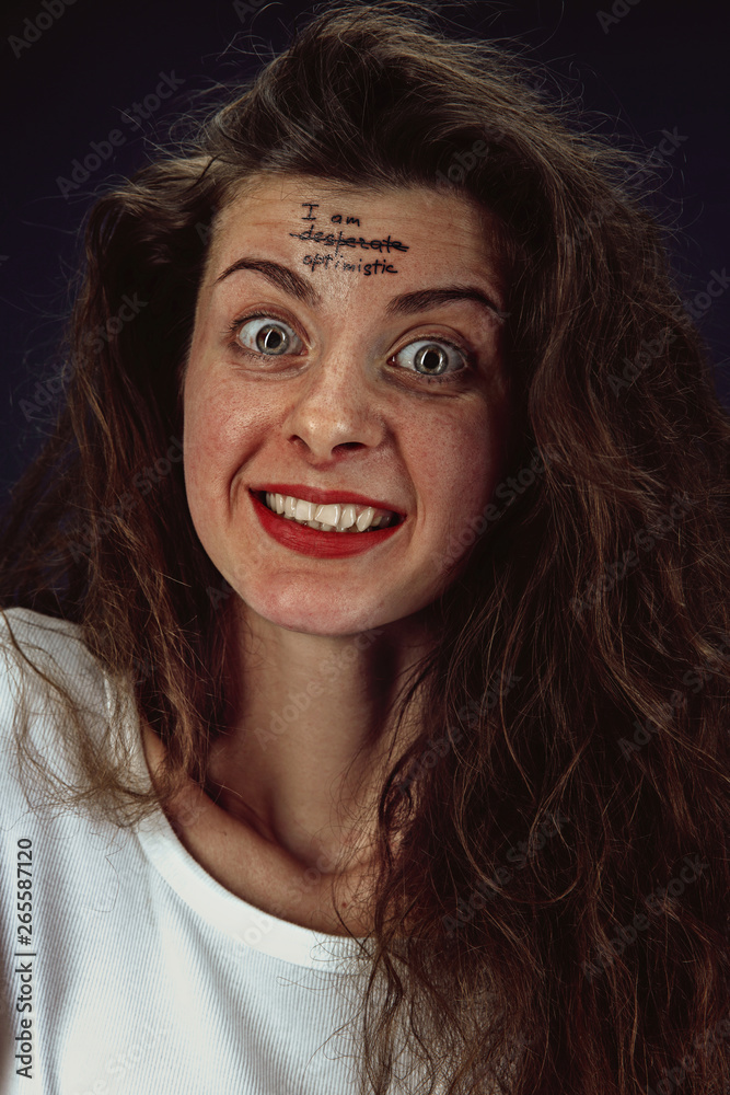 Portrait of young woman overcoming mental health problems. Tattoo on the forehead I'm desperate-optimistic. Concept of psycological trouble, treatment, rehabilitation, return to healthy lifestyle. Portrait of young woman overcoming mental health problems. Tattoo on the forehead I'm desperate-optimistic. Concept of psycological trouble, treatment, rehabilitation, return to healthy lifestyle.