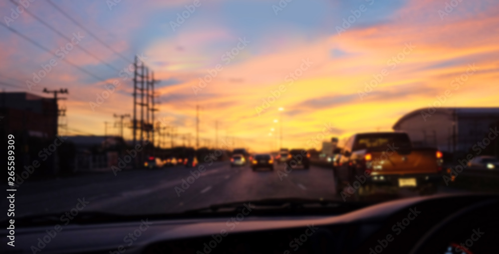 Blurred background of view from driving a car on the road at sunrise.