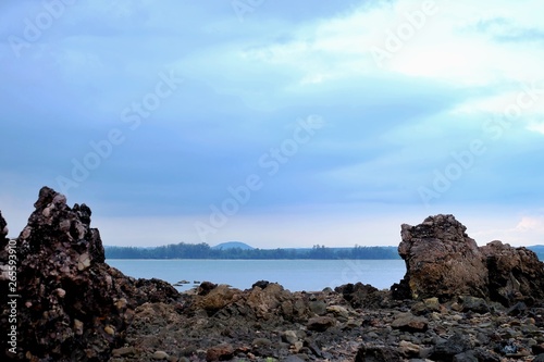 Silhouette seascape with sea stones shadow and blue sky background 