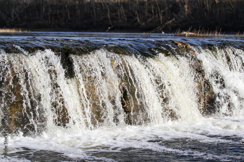 Beautiful view countryside waterfall with fish flying in river Venta.