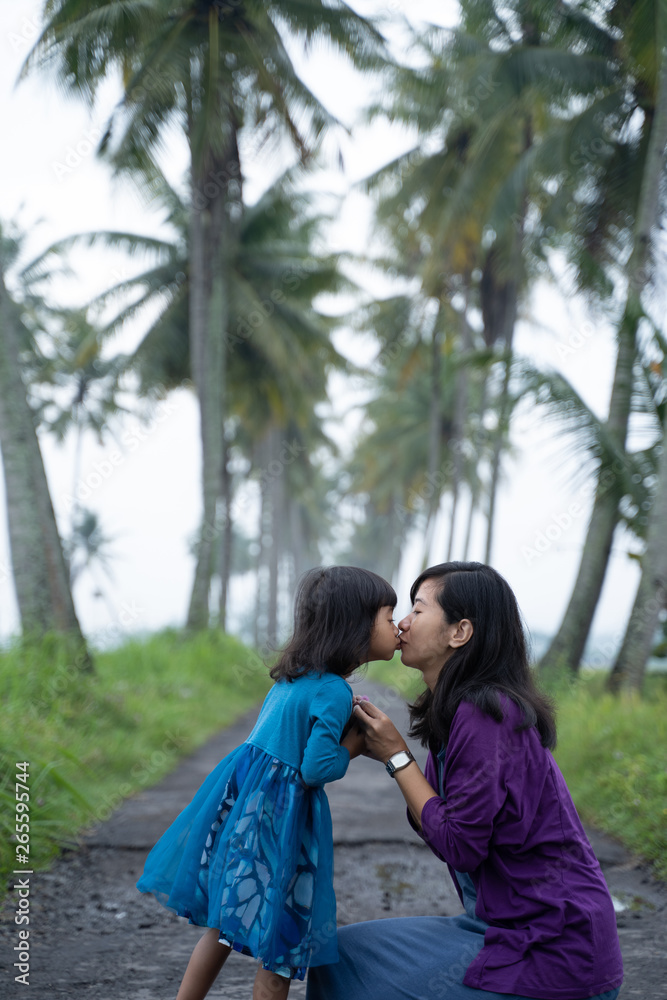 Naklejka premium mom and kid in beautiful coconut country road in the morning
