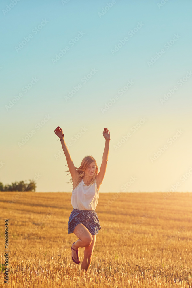 Young woman jumping and running in a wheat field. Young woman jumping and running in a wheat field.