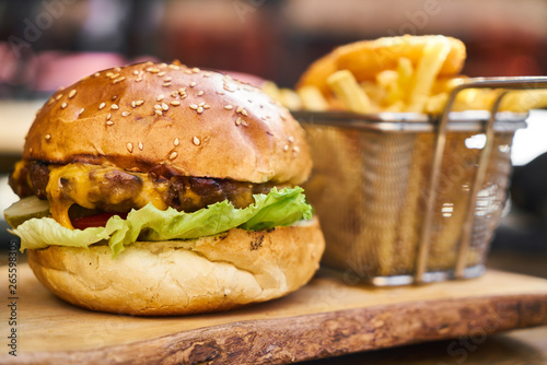 Cheeseburger with french fries on the wooden table
