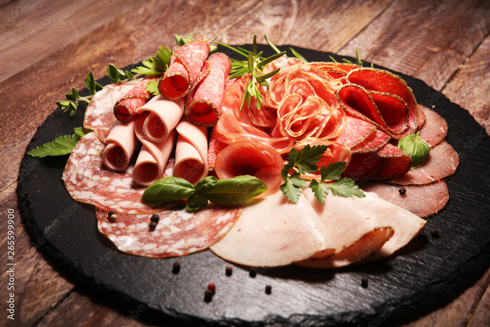 Food tray with delicious salami, pieces of sliced ham, sausages,salad and vegetable. Meat platter with selection Food tray with delicious salami, pieces of sliced ham, sausages,salad and vegetable. Meat platter with selection