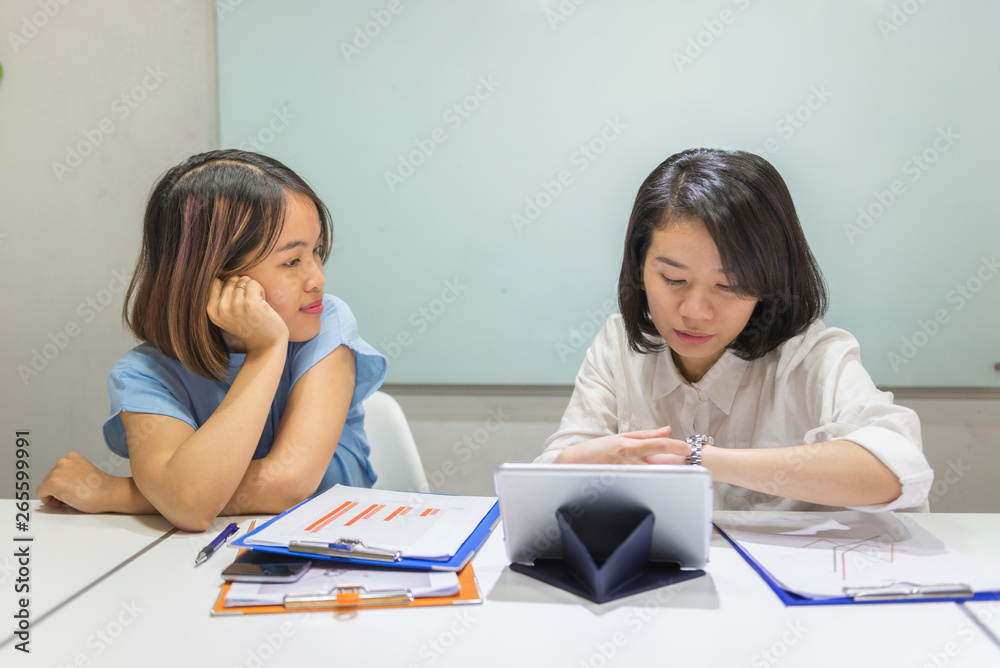 Asian office staff talk to each other in office Asian office staff talk to each other in office