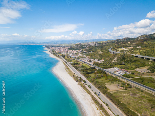 Vista aerea della città di Roccella Ionica o Jonica in Calabria, con il porto delle Grazie, il castello Carafa e la bellissima spiaggia sabbiosa con il mare Mediterraneo blu. 