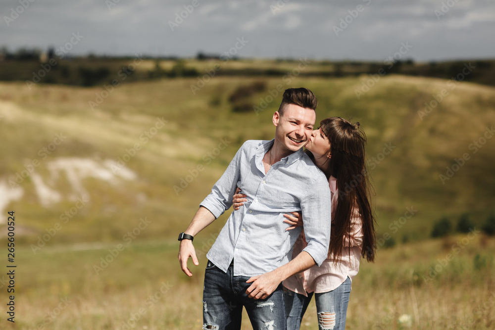 Young couple outdoor portrait. Beautiful pretty girl kissing handsome boy. Sensual photo. Young couple outdoor portrait. Beautiful pretty girl kissing handsome boy. Sensual photo.