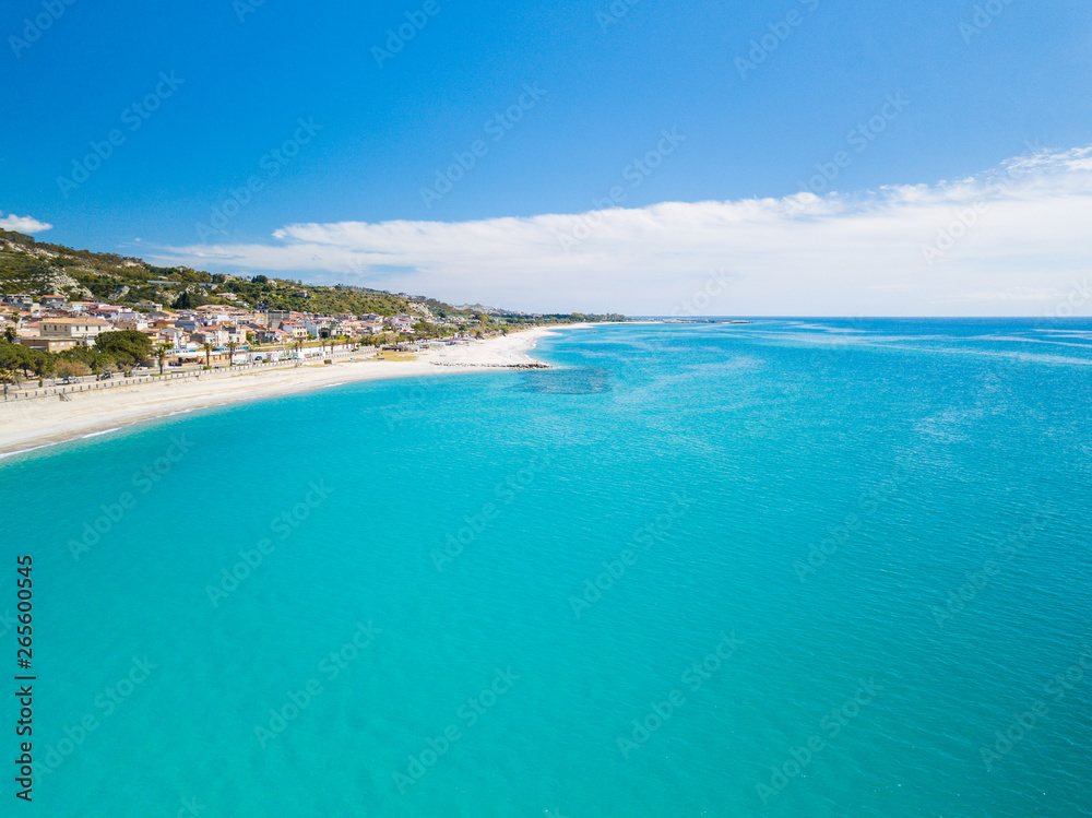 Roccella Ionica o Jonica, città in provincia di Reggio Calabria con affaccio sul mar Ionio Mediterraneo. Vista della costa sabbiosa, del castello e del porto dall'alto in Estate. Roccella Ionica o Jonica, città in provincia di Reggio Calabria con affaccio sul mar Ionio Mediterraneo. Vista della costa sabbiosa, del castello e del porto dall'alto in Estate.