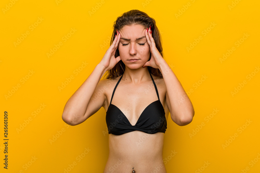 Young european woman wearing bikini touching his temples and having headache. Young european woman wearing bikini touching his temples and having headache.