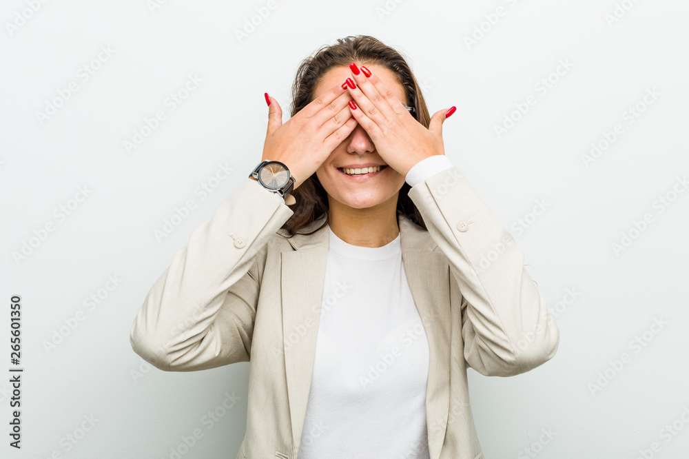 Young european business woman covers eyes with hands, smiles broadly waiting for a surprise. Young european business woman covers eyes with hands, smiles broadly waiting for a surprise.