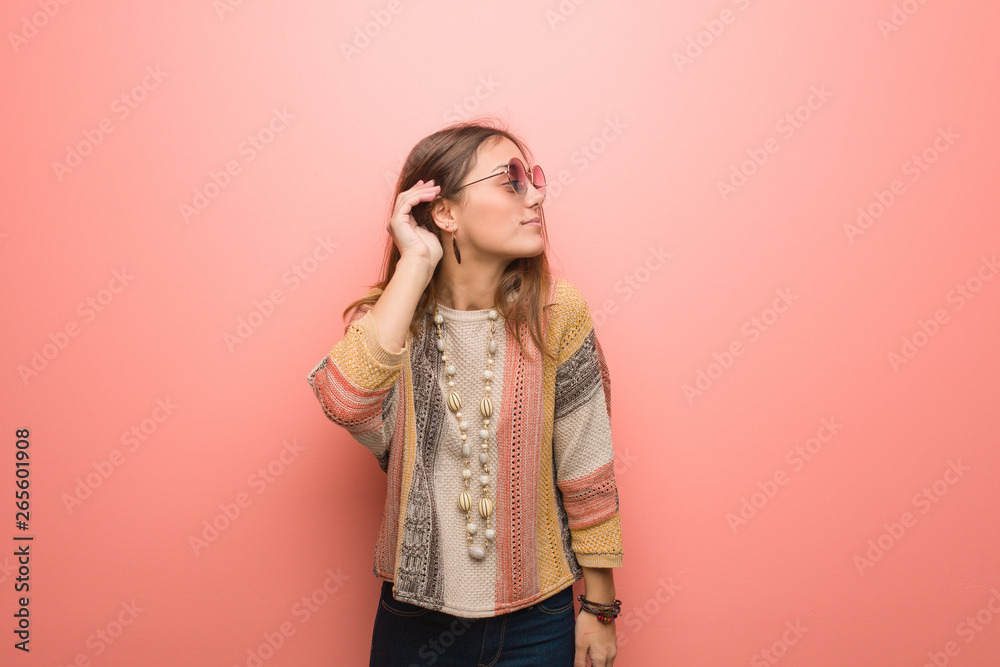 Young hippie woman on pink background try to listening a gossip Young hippie woman on pink background try to listening a gossip