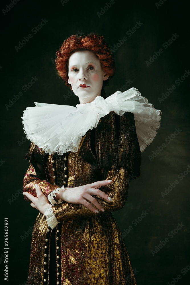 Too serious. Medieval redhead young woman in golden vintage clothing as ...