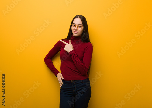 Intellectual young girl smiling and pointing to the side