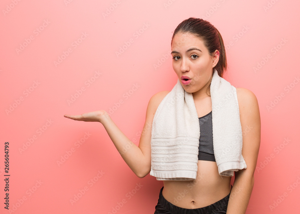 Young fitness woman holding something on palm hand Young fitness woman holding something on palm hand