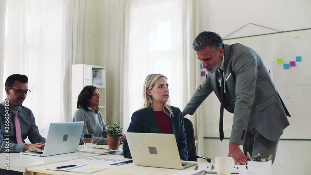 Group of young and old businesspeople with laptop working together in office. Group of young and old businesspeople with laptop working together in office.