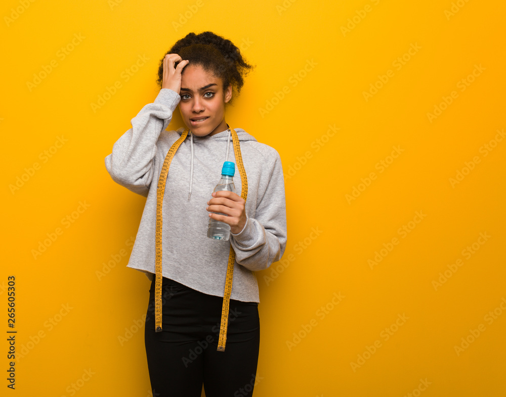 Young fitness black woman worried and overwhelmed.Holding a water bottle. Young fitness black woman worried and overwhelmed.Holding a water bottle.