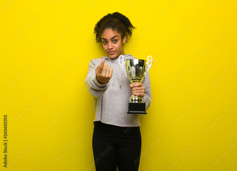 Young fitness black woman inviting to come. Holding a trophy. Young fitness black woman inviting to come. Holding a trophy.