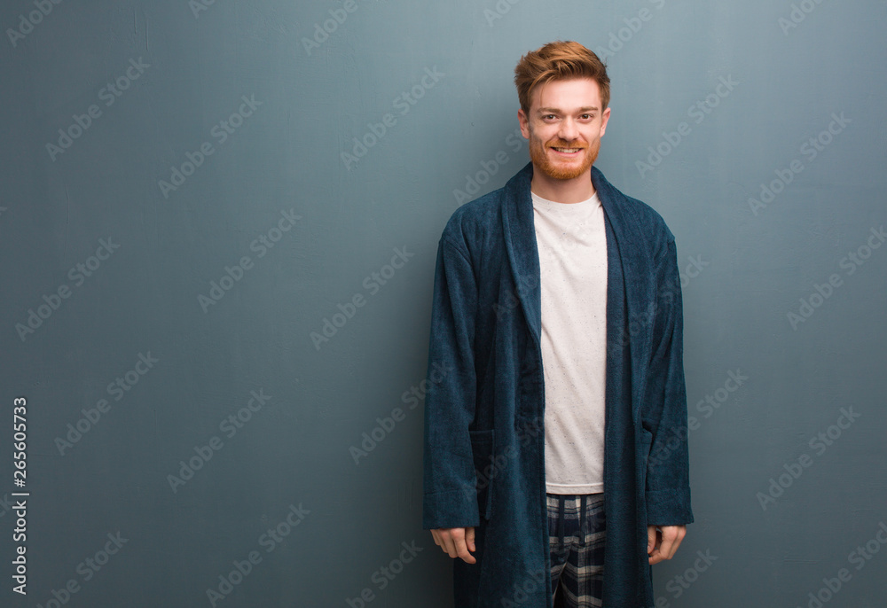 Young redhead man in pajama cheerful with a big smile - obrazy, fototapety, plakaty 