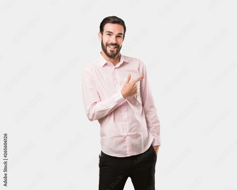 Young handsome man smiling and pointing to the side Young handsome man smiling and pointing to the side