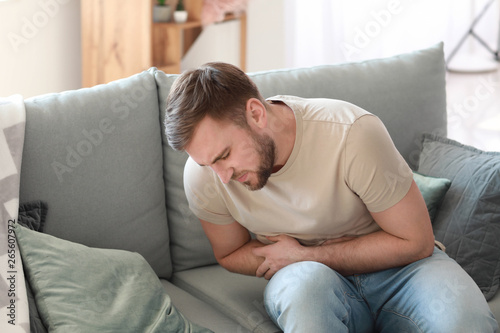 Young man suffering from stomachache at home