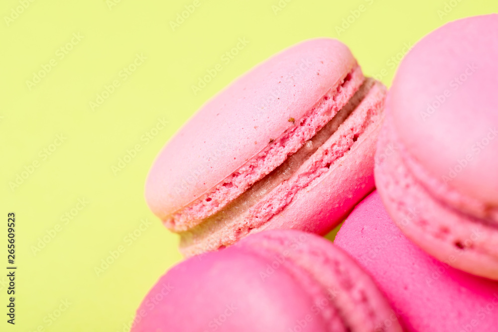tasty pink macarons with filling on yellow surface tasty pink macarons with filling on yellow surface