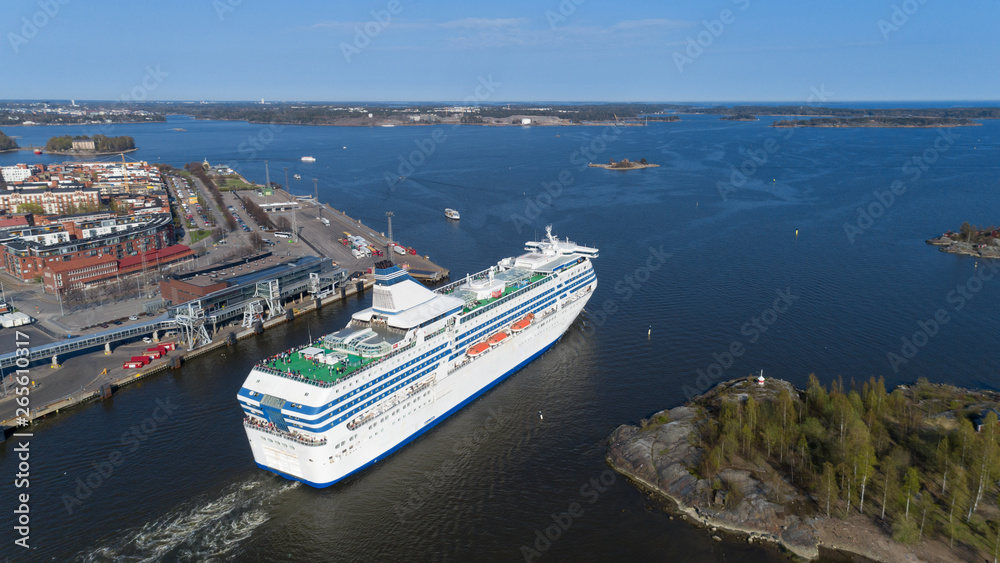 The cruise ship leaves the Helsinki port and enters the Baltic Sea through a narrow strait. Beautiful sunny spring panorama.