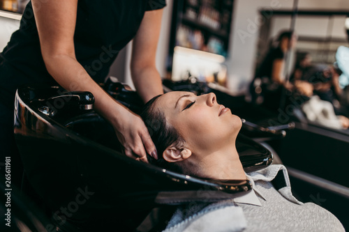 Beautiful young woman getting a hair wash. Hair salon styling concept.