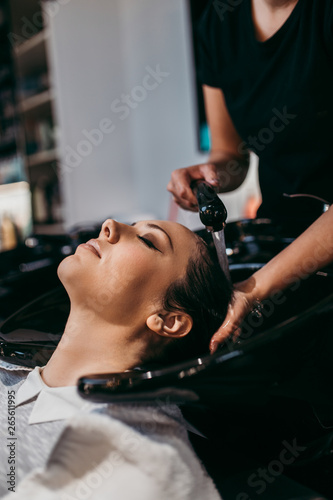 Beautiful young woman getting a hair wash. Hair salon styling concept.