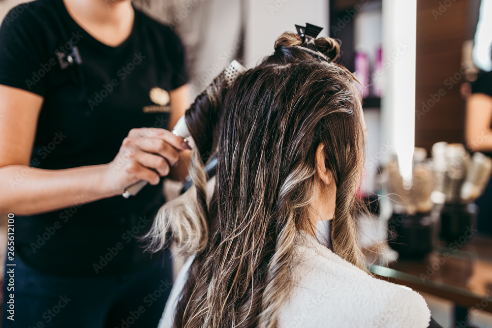 Beautiful brunette woman with long hair at the beauty salon getting a hair blowing. Hair salon styling concept. Beautiful brunette woman with long hair at the beauty salon getting a hair blowing. Hair salon styling concept.