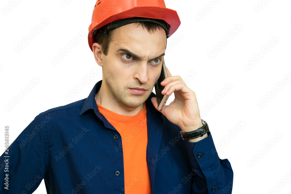 Builder with protective helmet on his head, furious, talking on the phone Builder with protective helmet on his head, furious, talking on the phone