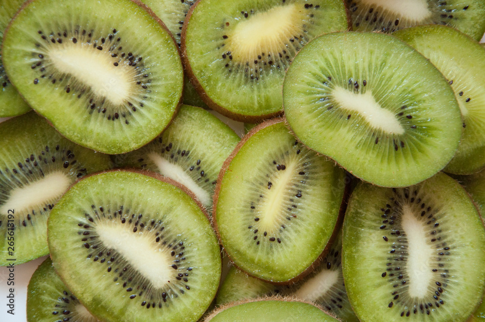 Kiwi sliced green background. Lots of green tropical fruits. Cut the kiwi into pieces. Kiwi sliced green background. Lots of green tropical fruits. Cut the kiwi into pieces.