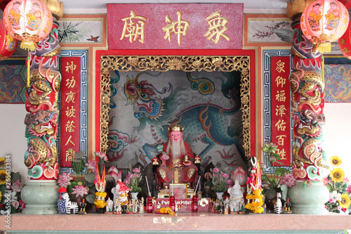 altar with offerings in a chinese temple (San Chao Pho Lak Muang) in Suphan Buri (Thailand)