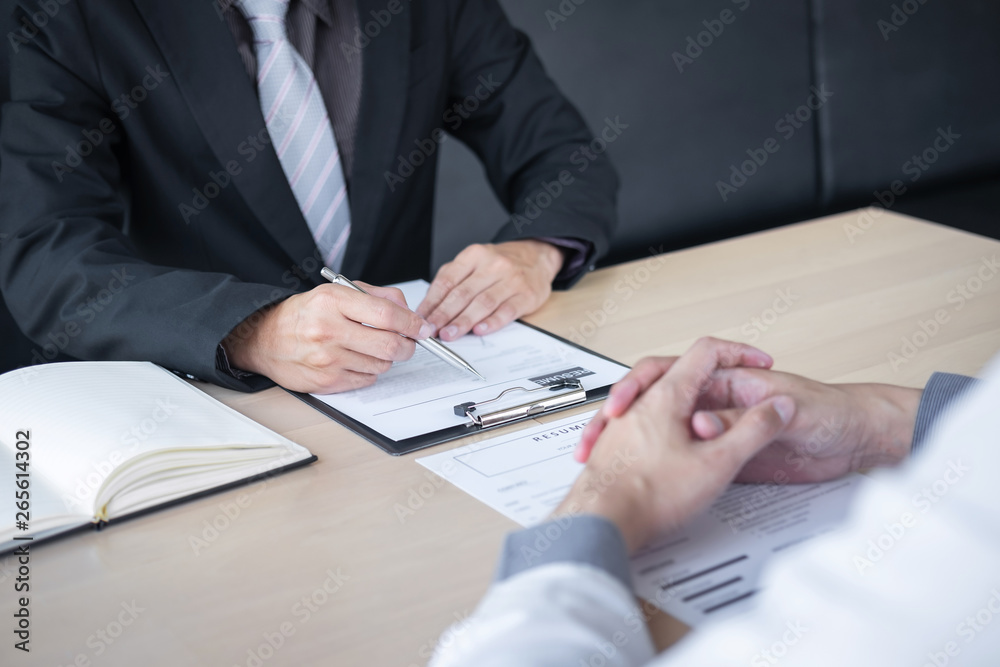 Employer or recruiter holding reading a resume during about colloquy his profile of candidate, employer in suit is conducting a job interview, manager resource employment and recruitment concept Employer or recruiter holding reading a resume during about colloquy his profile of candidate, employer in suit is conducting a job interview, manager resource employment and recruitment concept