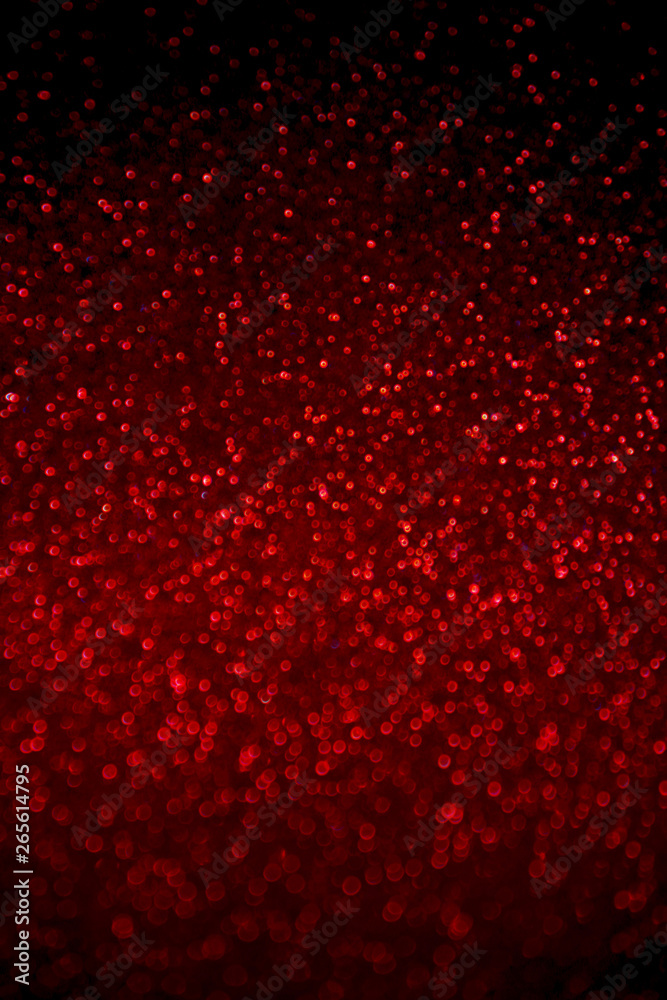 Abstract red glitter confetti sparkles on black background. Holiday background. Christmas concept. 