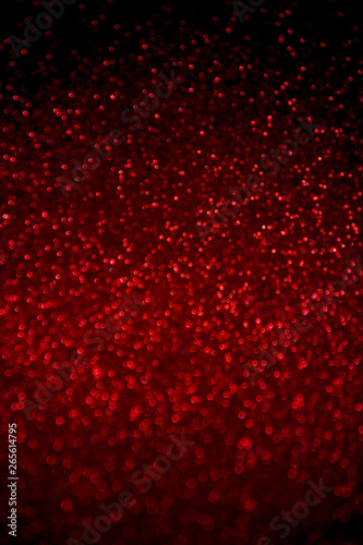 Abstract red glitter confetti sparkles on black background. Holiday background. Christmas concept. 