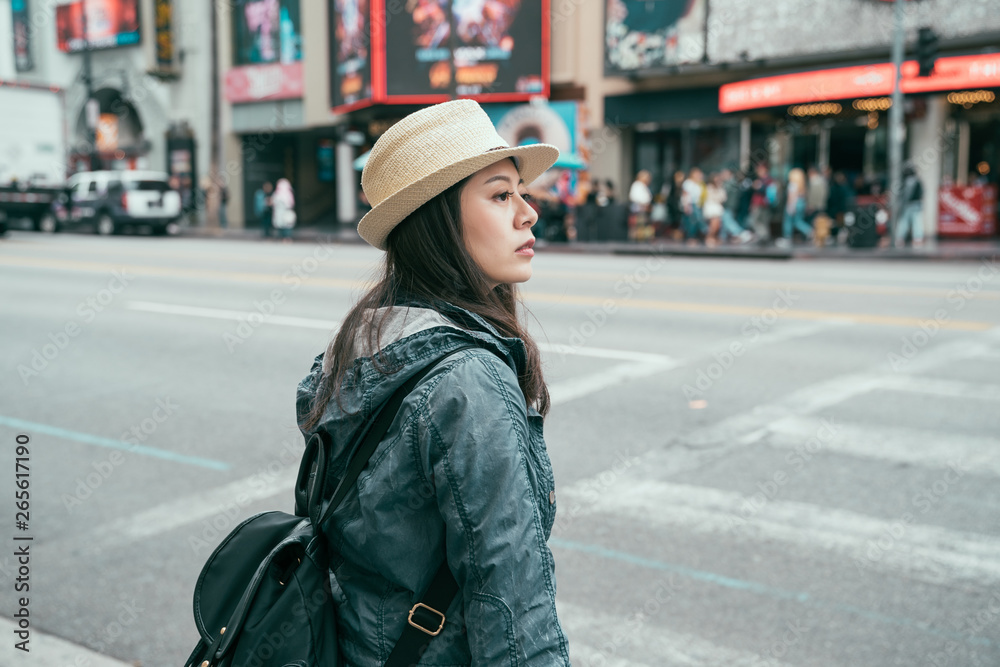 Urban style stylish beautiful asian woman traveler crossing zebra street wearing jacket. female tourist backpacker in spring wear and straw hat walking on road in hollywood boulevard los angeles usa Urban style stylish beautiful asian woman traveler crossing zebra street wearing jacket. female tourist backpacker in spring wear and straw hat walking on road in hollywood boulevard los angeles usa