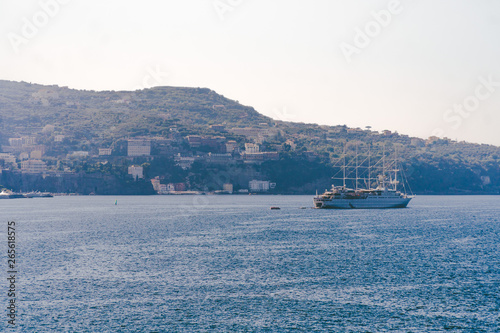 Fototapeta Naklejka Na Ścianę i Meble -  Luxury cruise ocean liner ship sailing from port on sunrise, sunset, Italy Sorrento bay, travel tour, work on the ship, vacancies, service, rest and holiday on the ship, space for text, Italy