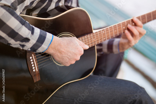 Young man sitting on steps playing guitar and singing, music concept