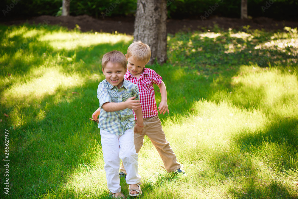 Fototapeta premium Two young boys walk and relax in the park.