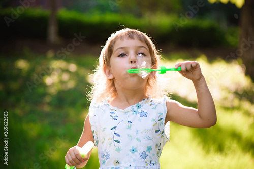 Girl with bubbles at a sunny summer evening