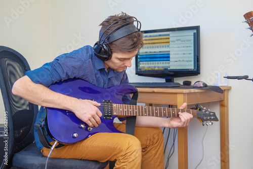 A man in headphones playing guitar.