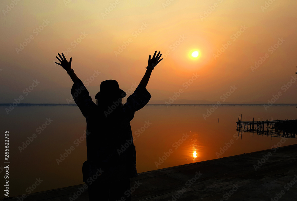 Fototapeta premium strong confidence woman open arms under the sunrise at seaside