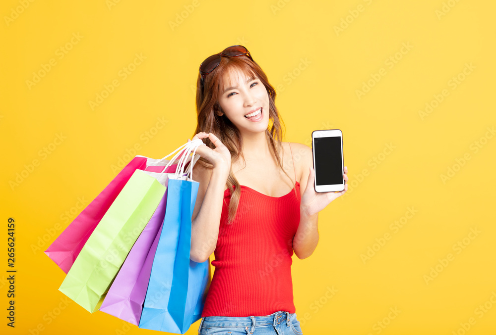 young woman holding shopping bags and smart phone young woman holding shopping bags and smart phone