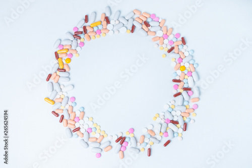 colored pills scattered in circle shape on white background with copy space for text. Opioid epidemic, painkillers and drug abuse concept