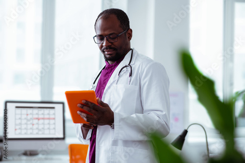 Medical scientist holding orange tablet working in laboratory photo