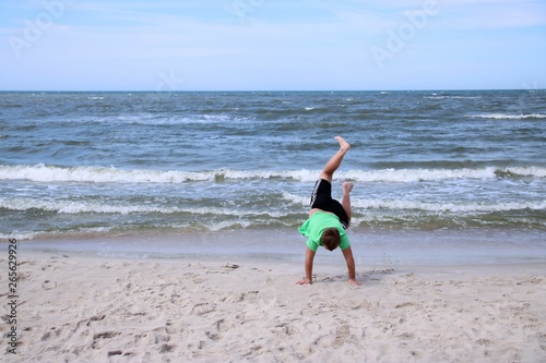 Chłopiec stojący na rękach na plaży