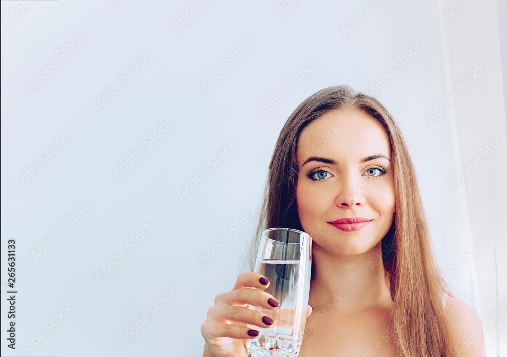 Healthy Diet Nutrition. Portrait Of Beautiful Young Woman Taking Vitamin Pill looking in windows. Closeup Of Happy Girl Holding Colorful Capsule Pill And Glass Of Fresh Water. Healthy Diet Nutrition. Portrait Of Beautiful Young Woman Taking Vitamin Pill looking in windows. Closeup Of Happy Girl Holding Colorful Capsule Pill And Glass Of Fresh Water.