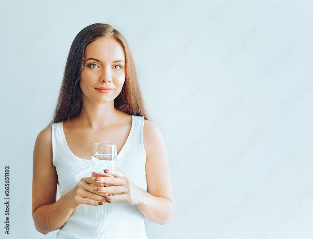 Healthy lifestyle. Portrait of happy smiling young woman posing on isolated studio background, hold water glass. Beautiful girl portrait. Female model poses. Healthy lifestyle. Portrait of happy smiling young woman posing on isolated studio background, hold water glass. Beautiful girl portrait. Female model poses.