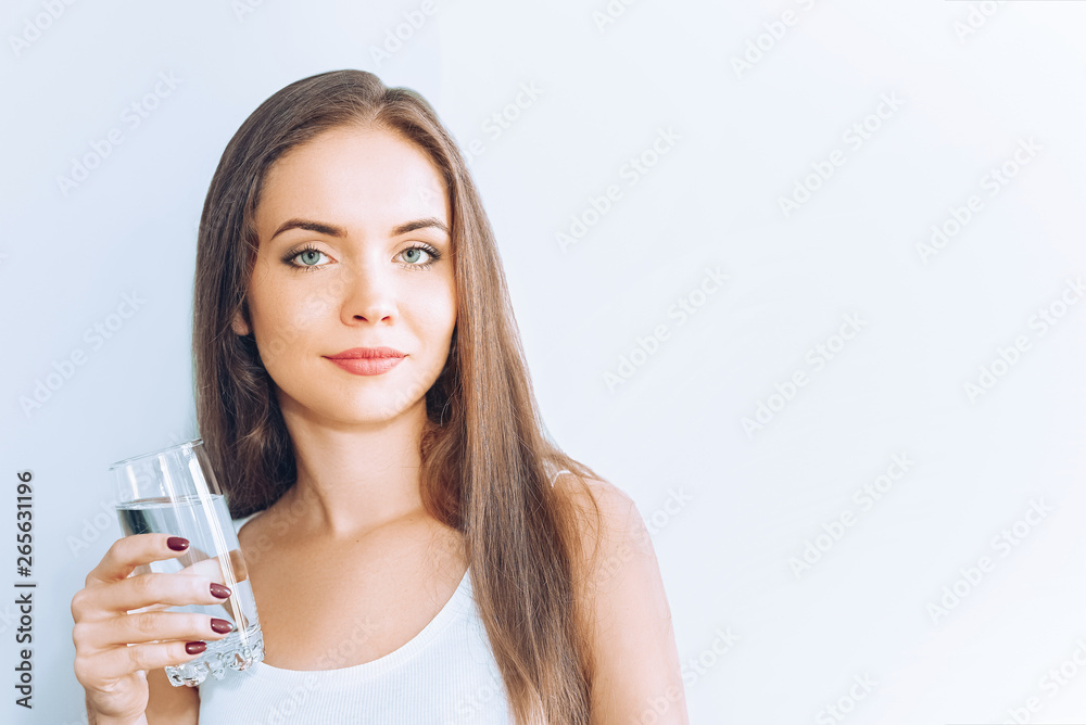 Healthy lifestyle.Young woman drinking from a glass of fresh water. Healthcare. Drinks. Portrait of happy smiling female model holding transparent glass. Health,Beauty,Diet concept. Healthy eating. Healthy lifestyle.Young woman drinking from a glass of fresh water. Healthcare. Drinks. Portrait of happy smiling female model holding transparent glass. Health,Beauty,Diet concept. Healthy eating.