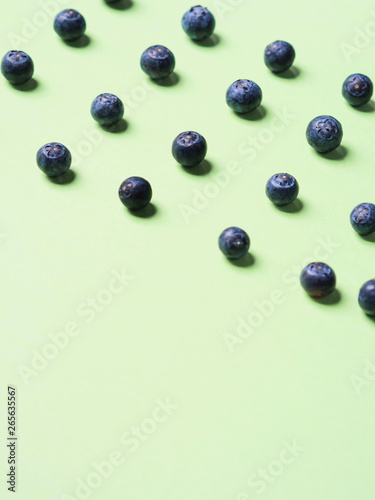 Pattern of fresh blueberries in on pastel green background. Healthy breakfast concept